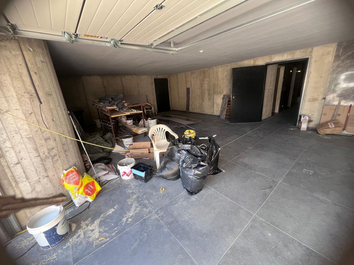 Garage a fine lavori prima della pulizia, con polvere e materiali di cantiere